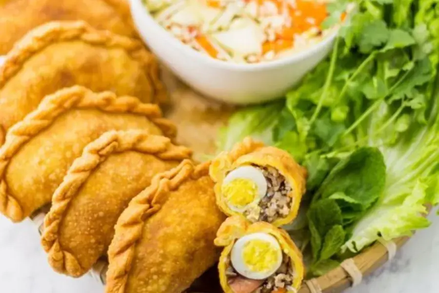 Bánh gối có thể cắt thành miếng nhỏ vừa ăn và ăn kèm cùng rau sống và dưa góp