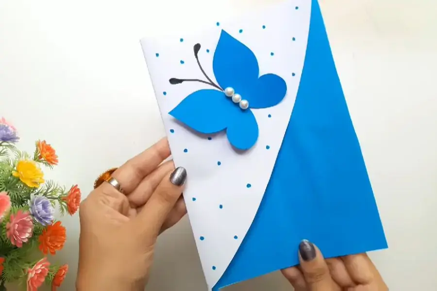 Cánh bướm xanh trên nền thiệp trắng vô cùng nổi bật.