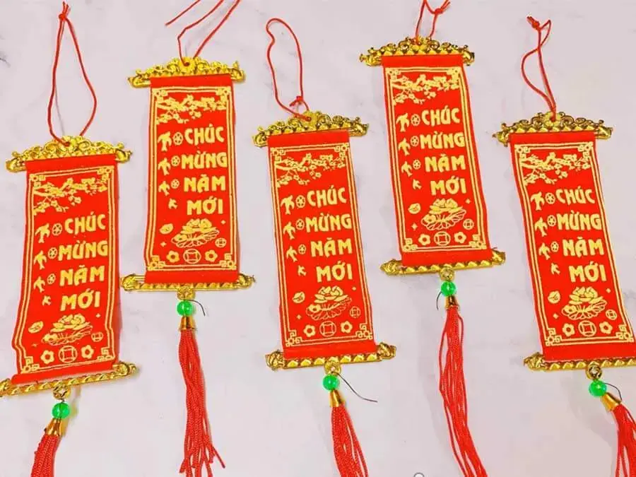 Liễn và câu đối Tết được dùng để trang trí cây mai.