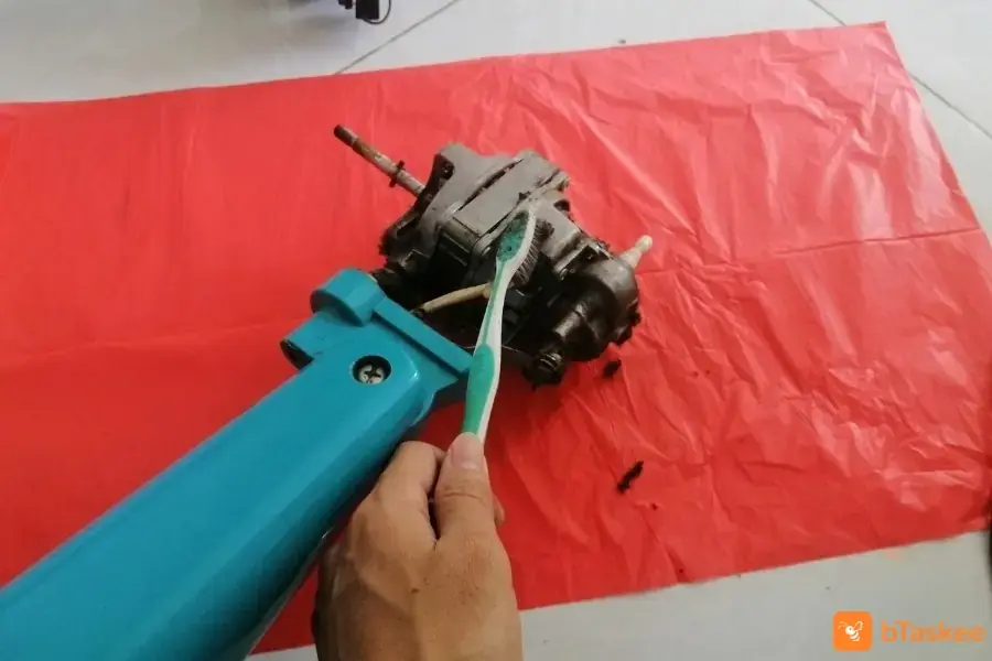 Dùng bàn chải lau bụi bẩn bám lên trục.