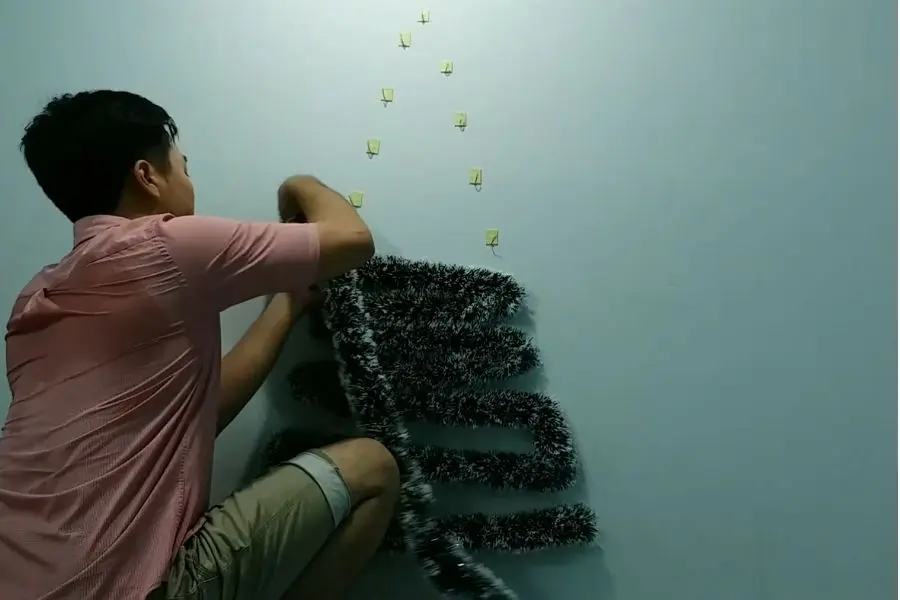 Dán dây kim tuyến lên đường theo nét vẽ phác họa.