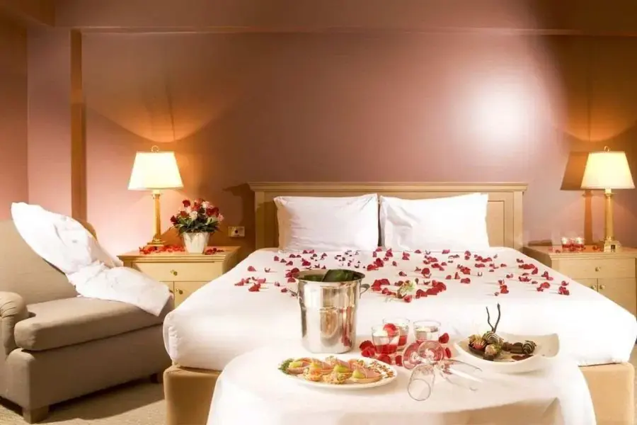 Rải những cánh hoa hồng lên giường cưới tạo không khí lãng mạn cho đêm tân hôn