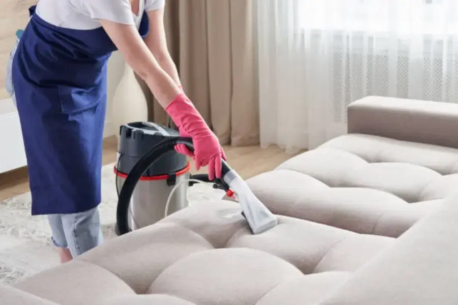 Dùng máy hút bụi hút sạch các bụi bẩn trên bề mặt ghế sofa