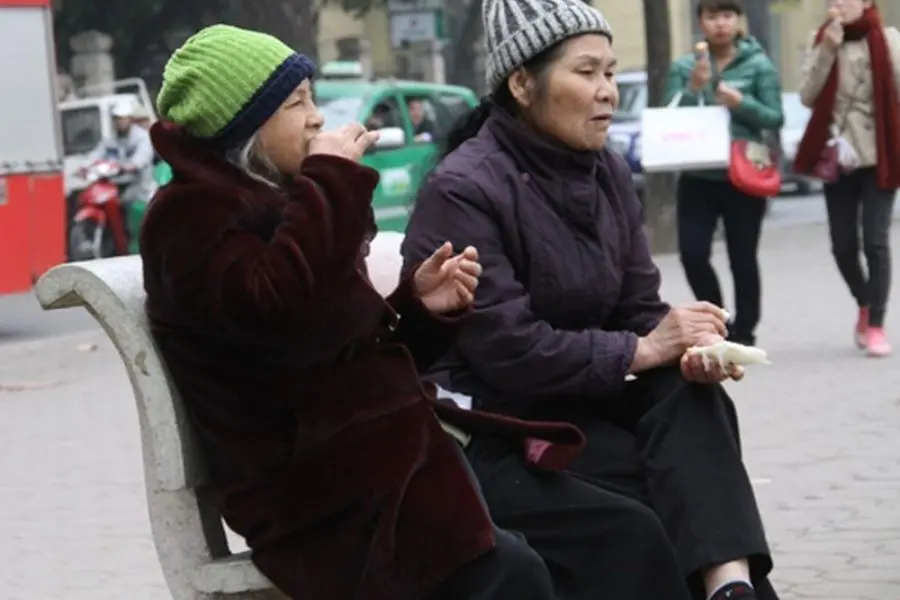 người già giữ ấm cơ thể vào màu đông bằng quần áo