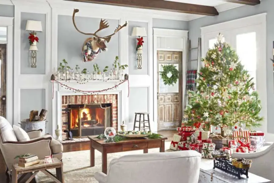 Mẫu trang trí Noel tại nhà dành cho khu vực phòng khách với cây thông Noel cùng đầu chú nai được đặt nổi bật phía trên lò sưởi. 