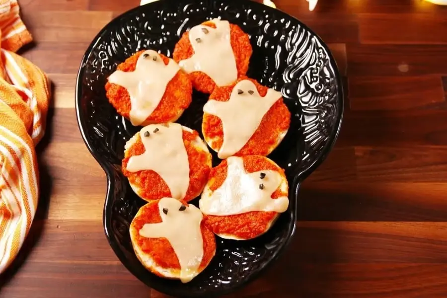 Chiếc pizza ma quái được sắp xếp trên đĩa với màu sắc và hình dáng rất đáng yêu.