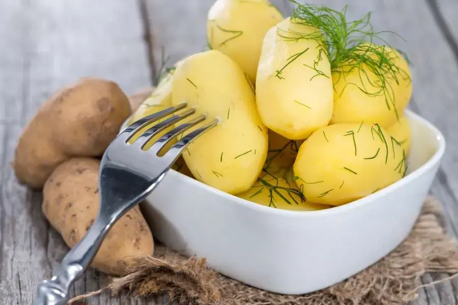 Ăn khoai lang luộc và rau chân vịt trong bữa tối