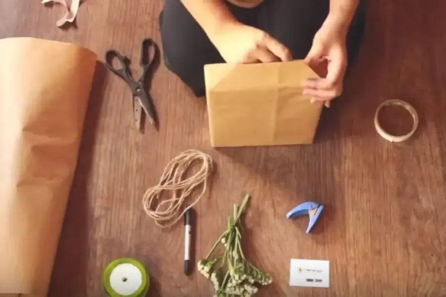 Gấp hai đầu hộp quà thành hình tam giác.