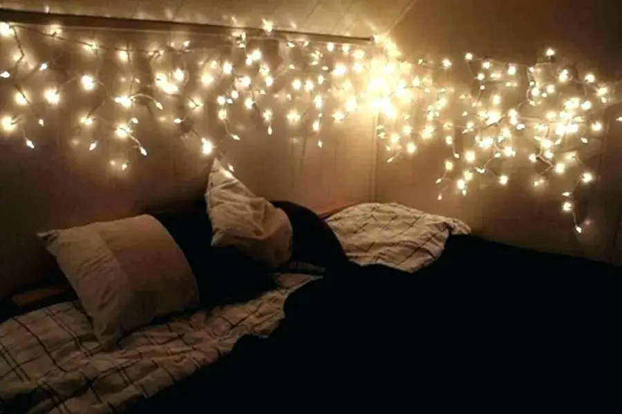 Có thể treo đèn xung quanh giường để tăng không khí ấm áp (Nguồn: Pinterest)