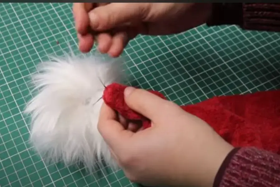 Dán chóp lông lên đỉnh mũ ông già tuyết.