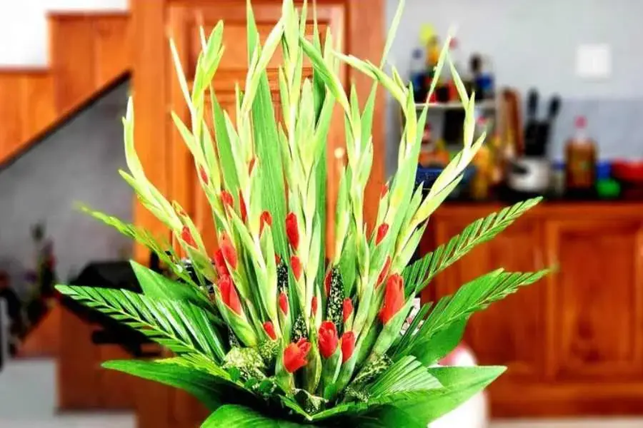 Thấm đều xốp vào nước và cho vào bình cắm, rồi cắm hoa vào miệng ở bên mép.