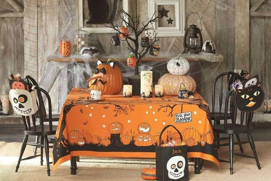 Mẫu trang trí bàn nước quán cà phê Halloween với bí ngô và mèo đen.