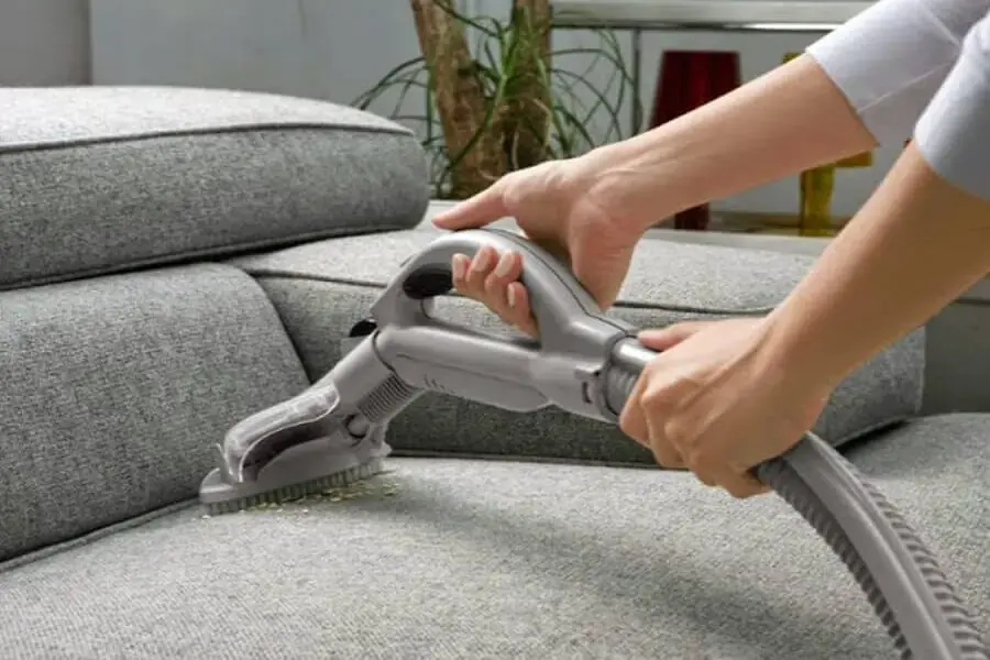 Dùng máy hút bụi để loại bỏ hết bụi bẩn nhỏ khó thấy trên ghế