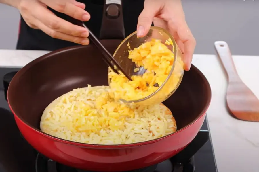 Dàn phô mai và trứng lên bề mặt đế bánh đã nướng vàng giòn.