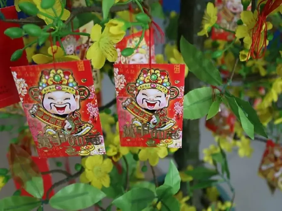 Dùng bao lì xì để trang trí cây mai ngày tết.