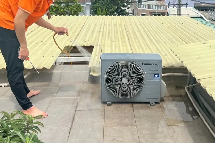 Nhân viên loại bỏ bụi bẩn ở cục nóng bằng dụng cụ chuyên dụng.