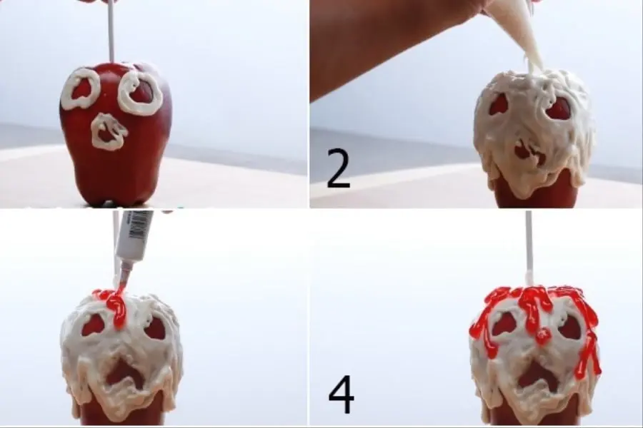 Vẽ mắt và miệng của hộp sọ lên quả táo và phủ socola trắng lên.