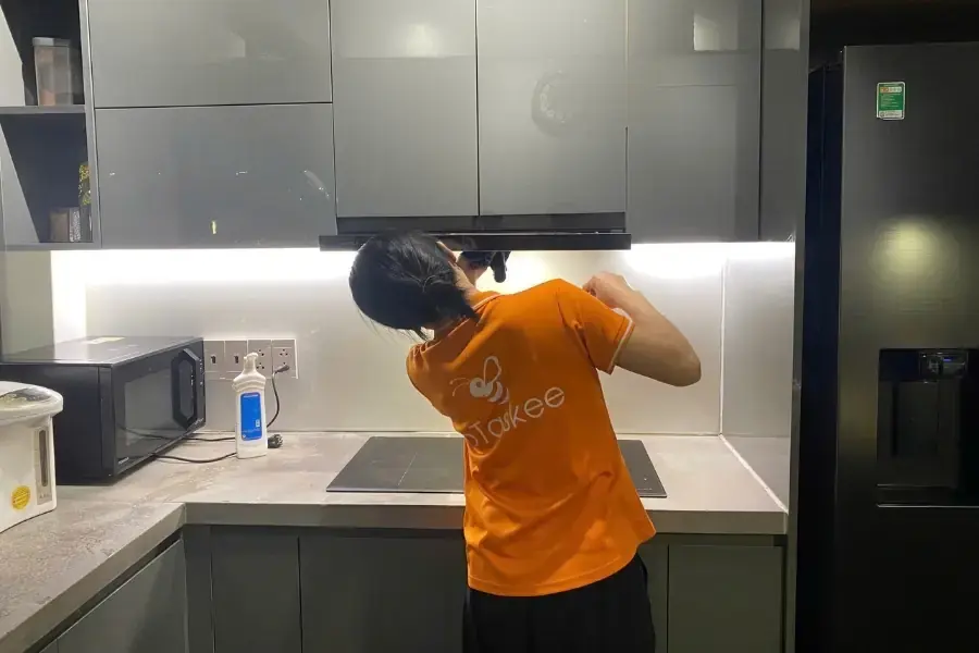 Hình ảnh chị Ong Cam đang vệ sinh khu vực nhà bếp.