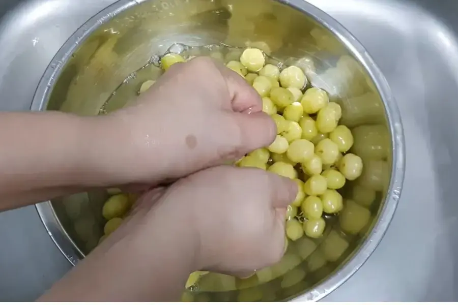 Vắt chùm ruột nhiều lần với nước.