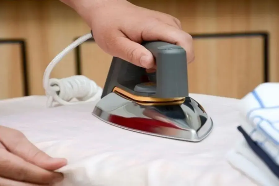Nhân viên ủi phẳng trang phục trước khi trả về khách hàng.