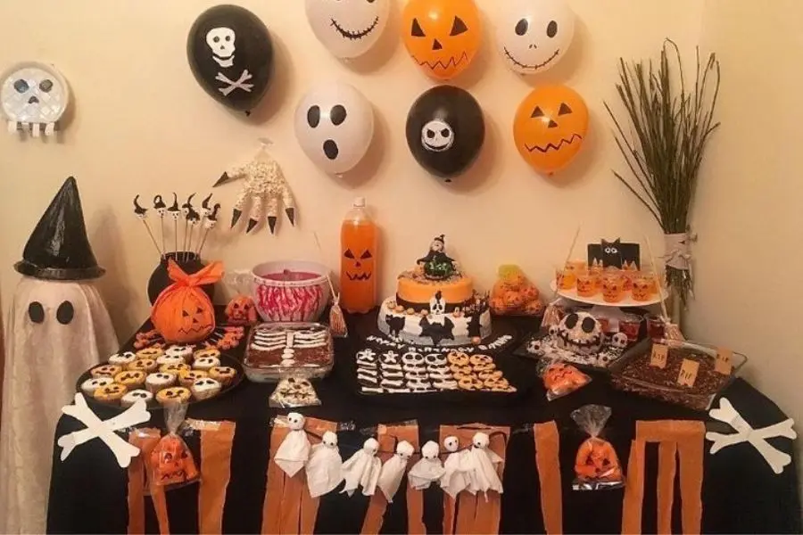 Trang trí bàn tiệc Halloween bắt mắt với bóng bay và bánh kẹo.