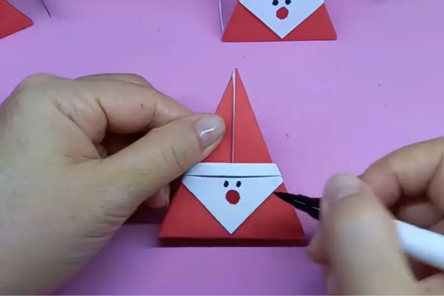 Dùng bút dạ tạo hình mũi và mắt của Ông già Noel.