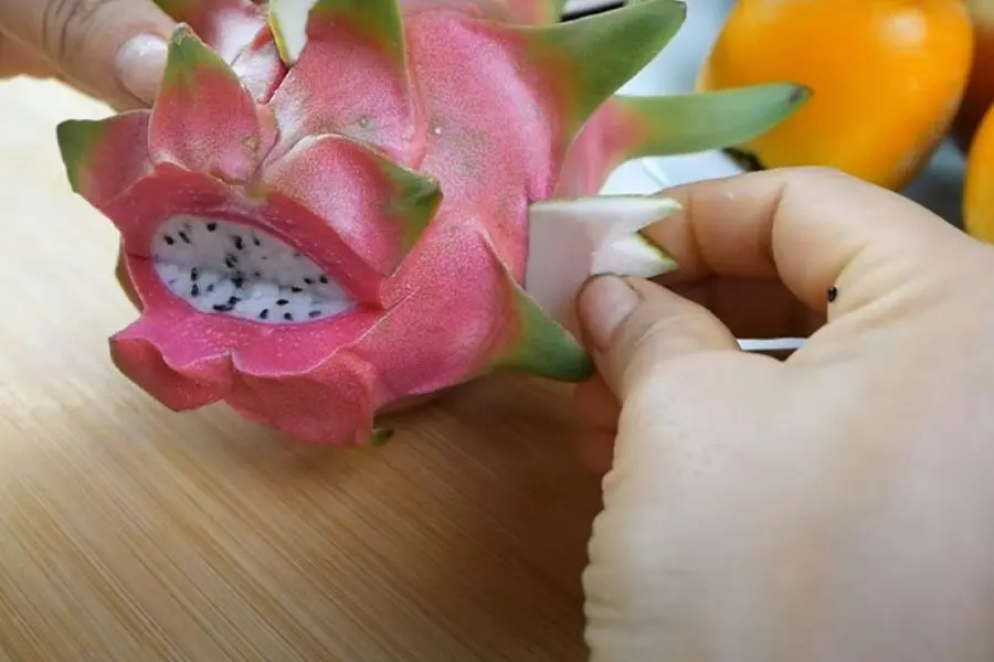 Gắn vây cá vào 2 bên của quả thanh long.