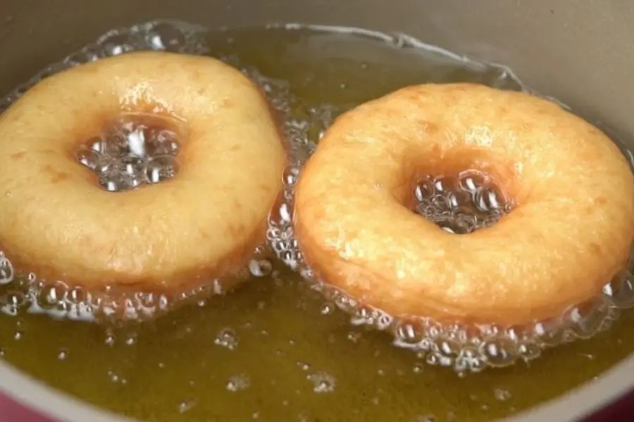 2 chiếc bánh donut đang chiên ngập dầu