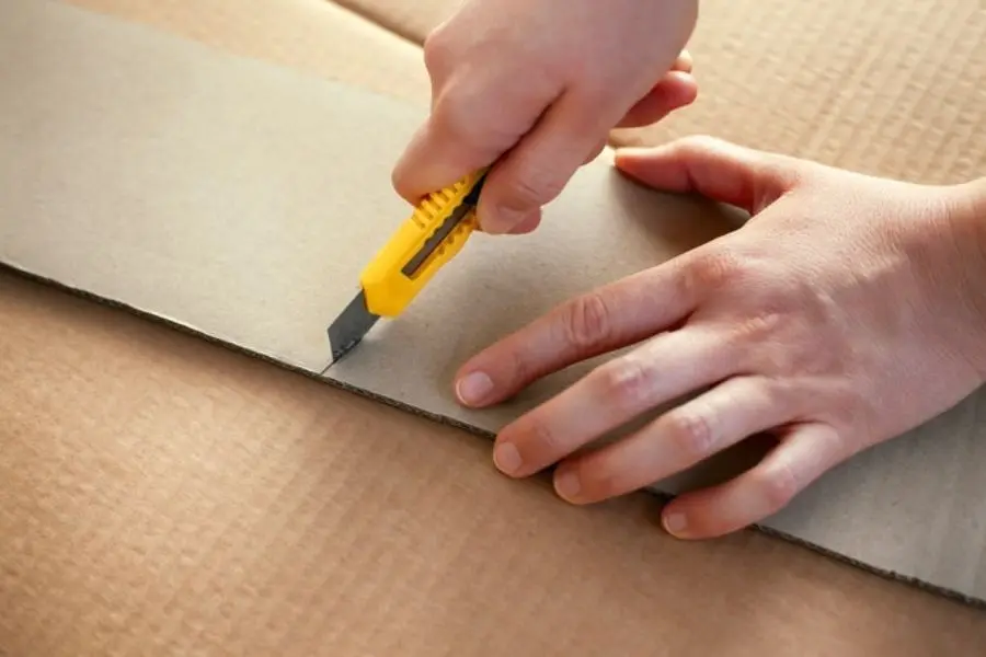 Dùng dao rọc giấy cắt dọc theo các cạnh của hộp sữa.