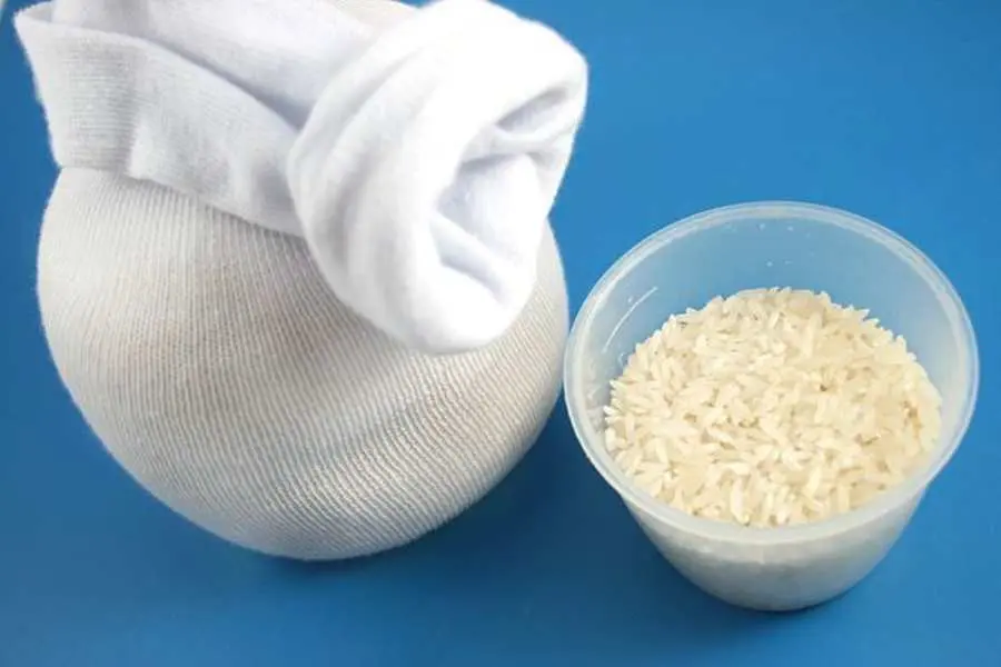 Cho một ít gạo vào bên trong chiếc tất vừa chuẩn bị.