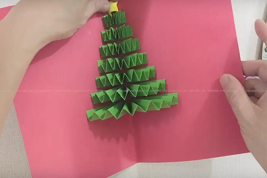 trang trí thêm ngôi sao trên đỉnh đầu cây thông noel