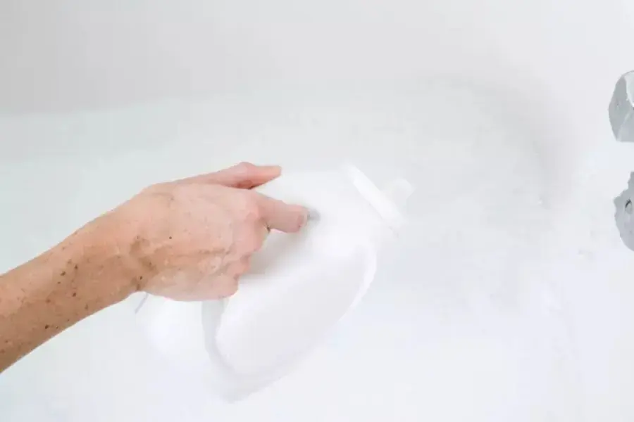 Pha loãng nước giặt rồi đổ từ từ hỗn hợp nước giặt lên chăn.