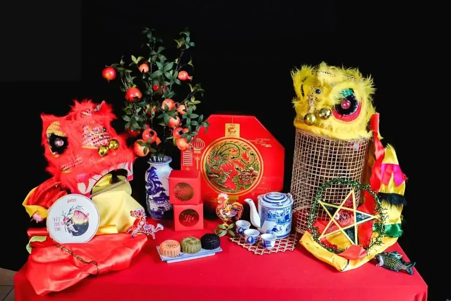 Trang trí Trung thu với phụ kiện, bánh trà và cành cây cảnh.