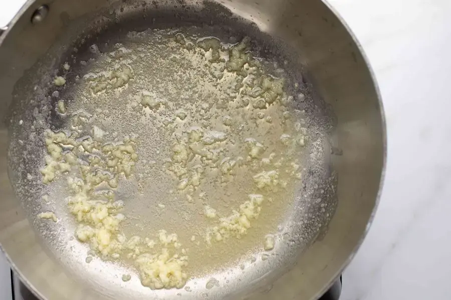 Phi thơm tỏi và cho nấm vào đảo đều tay