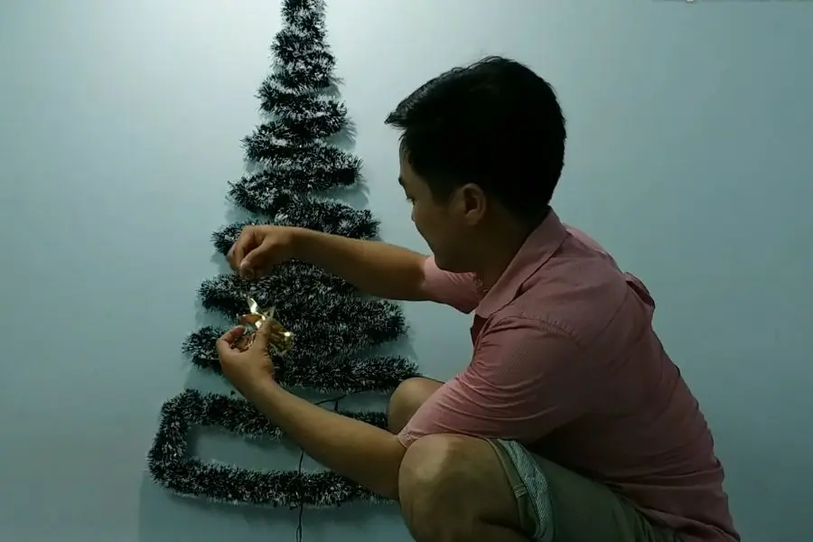 Treo dây đèn Led lên cây thông.