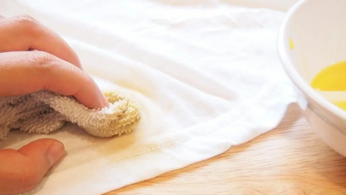 dùng vải thấm dung dịch để tẩy vết bẩn trên áo