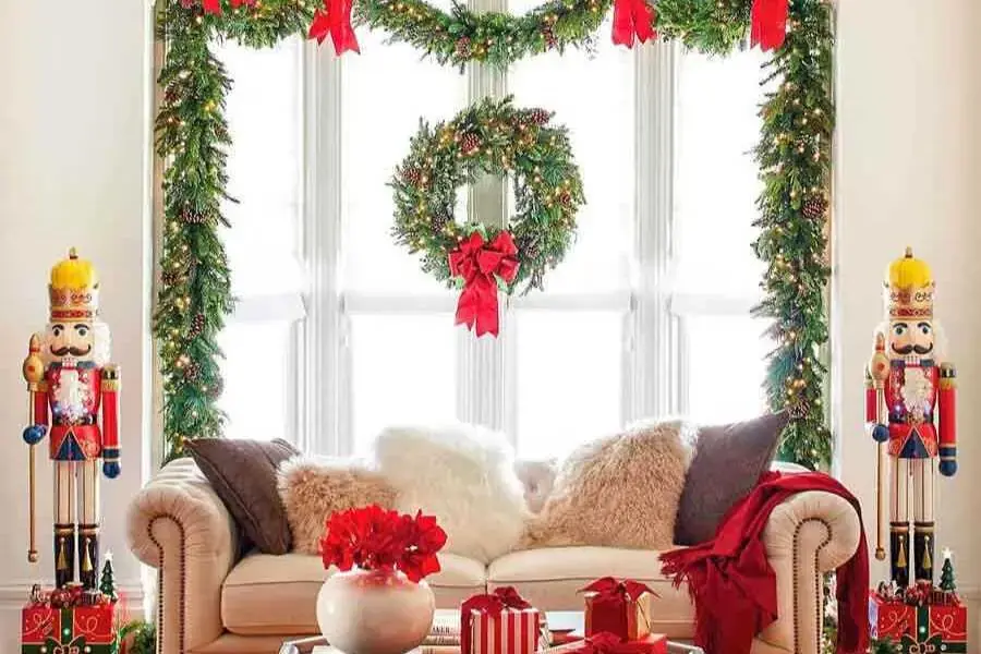 Ý tưởng trang trí Noel dành cho phòng khách với bộ khung viền được làm từ nhành thông tươi mát và phụ kiện màu đỏ nổi bật. 