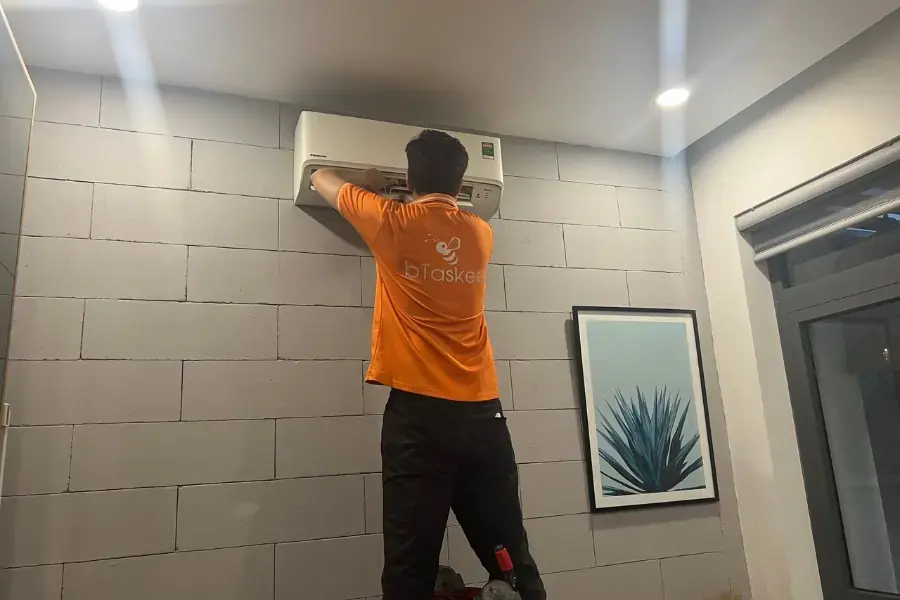 Kỹ thuật viên bTaskee đang cẩn thận vệ sinh máy lạnh.