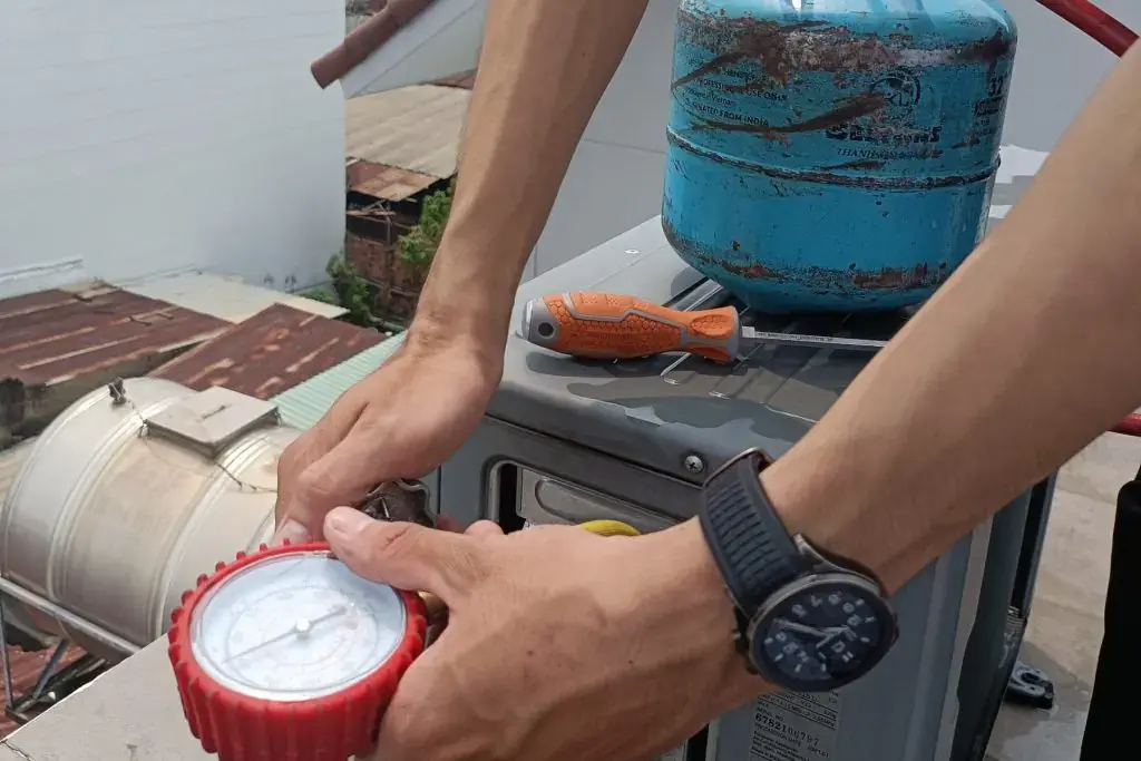 Tasker vệ sinh máy lạnh của bTaskee đang tiến hành bơm gas máy lạnh.