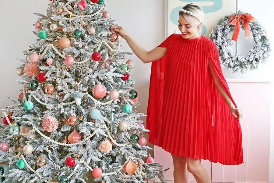 Nếu mặc váy, bạn có thể nhẹ nhàng cầm tà váy và đặt nhẹ tay lên cây thông Noel khi chụp ảnh.