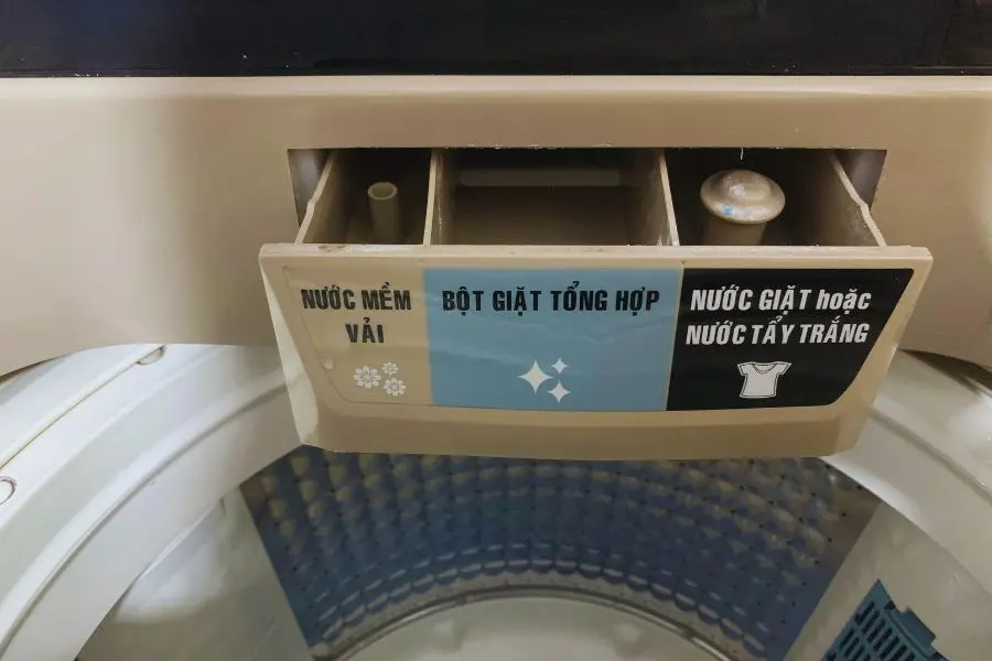 Dùng nước ấm và bàn chải mềm để cọ rửa khay đựng nước xả, bột giặt.